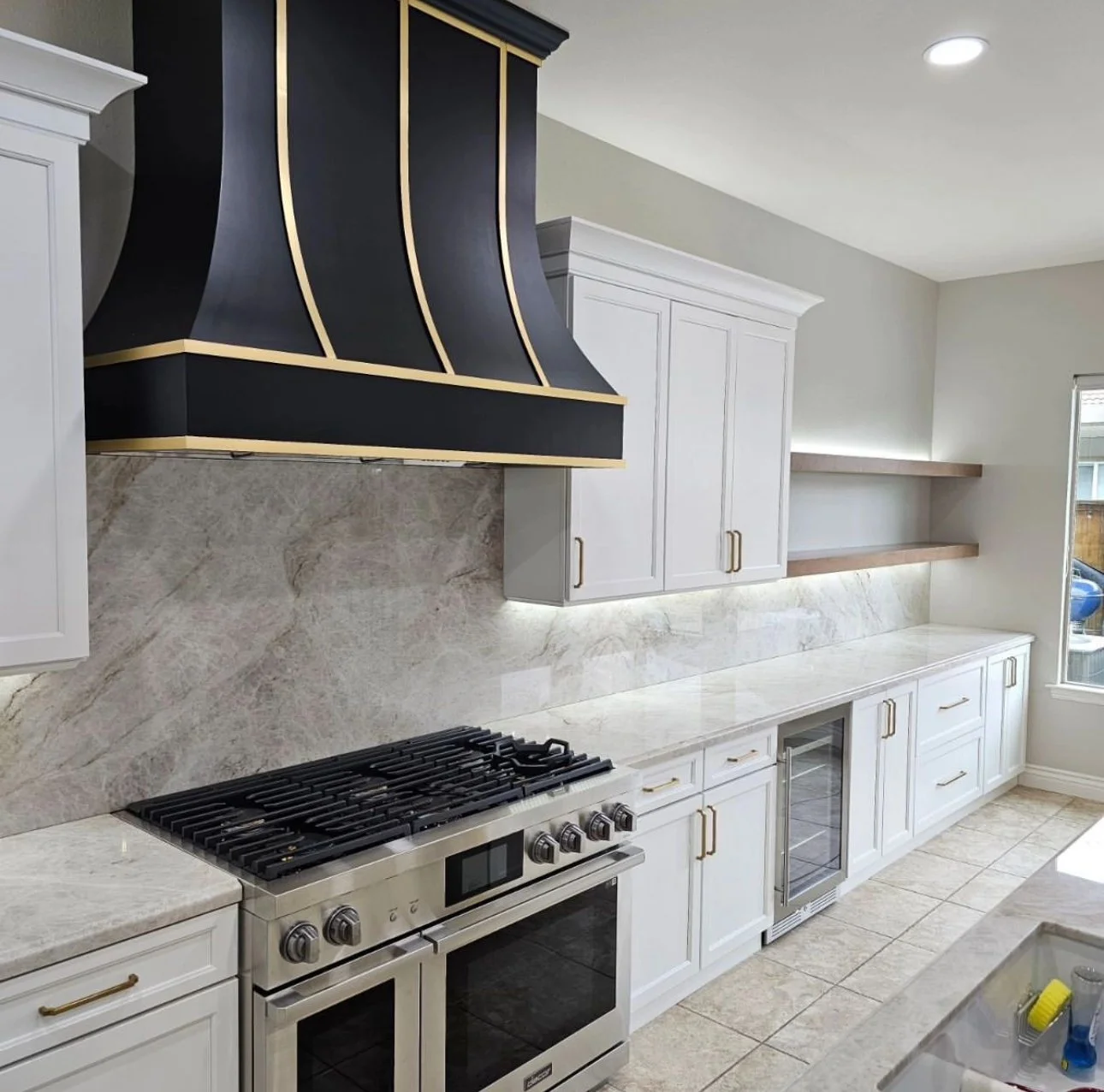 White shaker kitchen with black gold range hood